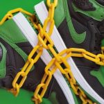 New Culture - Stylish sporty boots chained on green surface