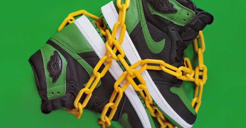 New Culture - Stylish sporty boots chained on green surface