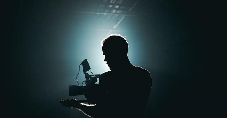 Camera Gear - Silhouette of Man Standing in Front of Microphone